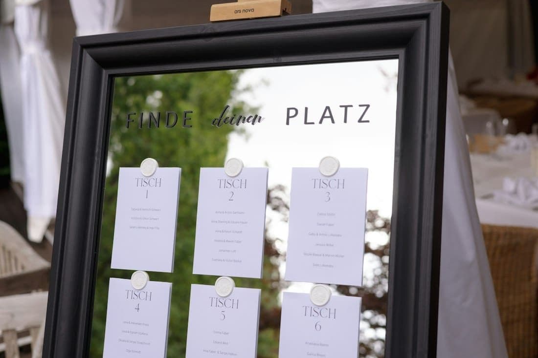 A wedding seating chart with table cards on a mirror
