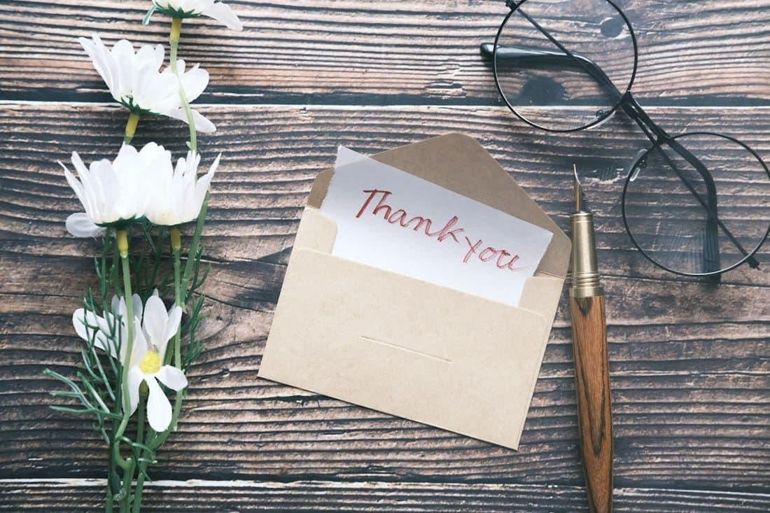A handwritten thank-you note in a kraft envelope